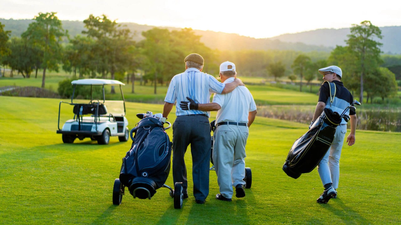 Middle aged man playing golf in a grass field